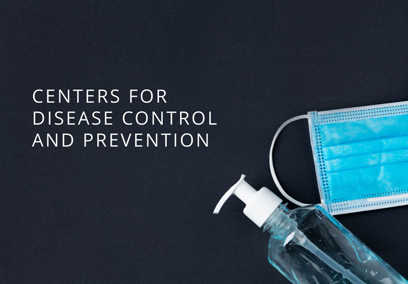 Blue background with white text reading Centers for Disease Control and Prevention. Image has a medical face mask and a bottle of hand sanitizer.