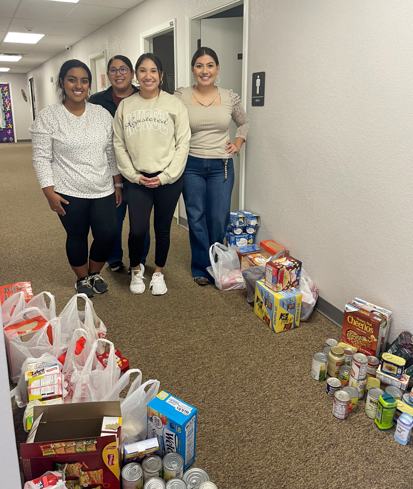 Students from the Student Nurses Association Club pose alongside bags of donations.