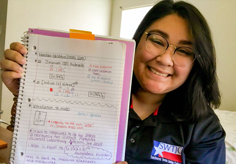 female student holding notebook with written notes