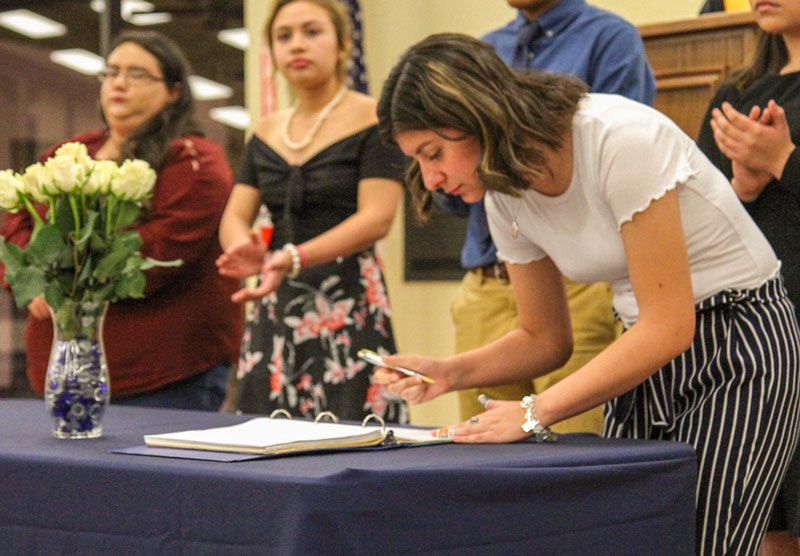 Female student signing a document