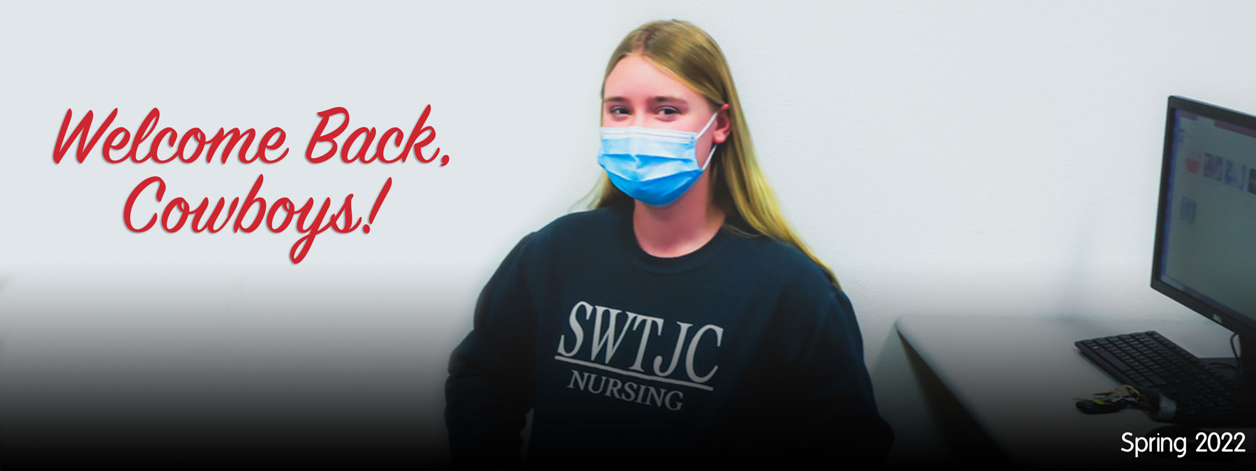 Masked female student wearing a blue SWTJC Nursing sweatshirt sitting in a classroom. Informative Text: Welcome Back, Cowboys!